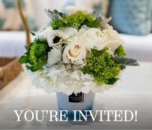 A white and green floral arrangement from Hive Floral Workshop x Baobab Collection by Hive Floral Studio sits in a vase on a table with “YOU’RE INVITED!” overlaid at the bottom.