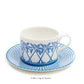 A fine bone china coffee cup with a handle and blue geometric palm pattern from the Azure Blue Dinnerware Collection by Pink House Mustique sits on a matching saucer, evoking Exotic Tropics on crisp white.