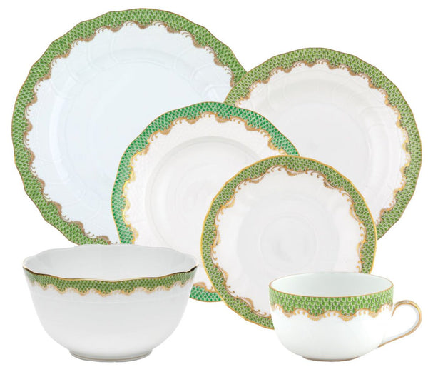 The Herend Fish Scale Evergreen Collection by Herend is a white dinnerware set adorned with green and gold decorative trim, featuring plates of various sizes, a bowl, and an elegant hand-painted teacup with a handle—perfect as an anniversary gift.