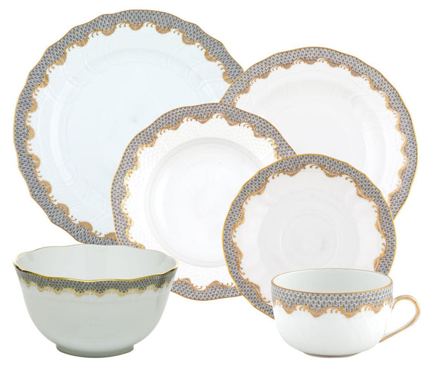 A set from the Herend Fish Scale Gray Collection by Herend, featuring plates, a bowl, and a teacup with matching saucer. Each piece boasts an elegant patterned rim adorned with gold and blue accents, highlighted by hand-painted designs that elevate artistic appreciation.