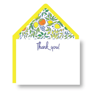 The Yellow Thank You Note Set by Haute Papier features a card with “Thank you!” in blue script and a yellow envelope lined with a colorful fruit and leaf pattern.