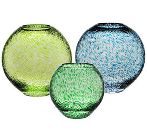 The Globe Vase Collection from William Yeoward Crystal features three round vases in green, yellow-green, and blue with a speckled pattern, presenting a contemporary design against a crisp white background.