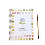 A spiral-bound Emily Lex Studio Watercolor Workbook, titled “Flowers,” features a painted hydrangea on the cover bordered by colorful squares and sits next to a paintbrush—perfect for your next watercolor art activity.