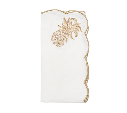 The Pina Punch Napkin Set by Kim Seybert features white linen napkins with gold scalloped edges and an embroidered gold pineapple, perfect for elevating any table setting.