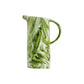 The Nashi Home Serveware Collection, Forest by Nashi Home features a green and white marbled ceramic pitcher with a handle—perfectly pairing with any BPA-free resin serving piece for a modern table setting.