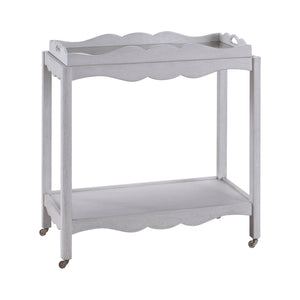 The Lawson Bar Cart by Branch Home features two white wooden tiers with scalloped edges, a magnetic tray, and four small caster wheels—perfect for serving drinks.
