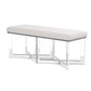 The Lex Bench by Made Goods features a light gray upholstered seat atop clear acrylic legs, showcasing modern elegance through its minimalist rectangular design.