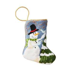 The Frosty Needle Point Stocking by Bauble Stockings features hand-stitched needlepoint with a snowman, green tree, and gold hanging loop—an heirloom Christmas stocking set on a plain white background.
