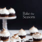 Swirled chocolate cupcakes are displayed on a stand and table, surrounded by marshmallows and chocolate pieces for a tempting comfort food scene. The cover features the title “Bake the Seasons” from Penguin Random House, evoking the heart of seasonal baking recipes against a dark backdrop.