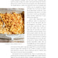 A baked macaroni and cheese dish topped with breadcrumbs sits in a white casserole dish beside a serving spoon on a white background, making it the perfect choice for fans of comforting recipes and easy dinner ideas featured in *Go-to Dinners* from Penguin Random House.