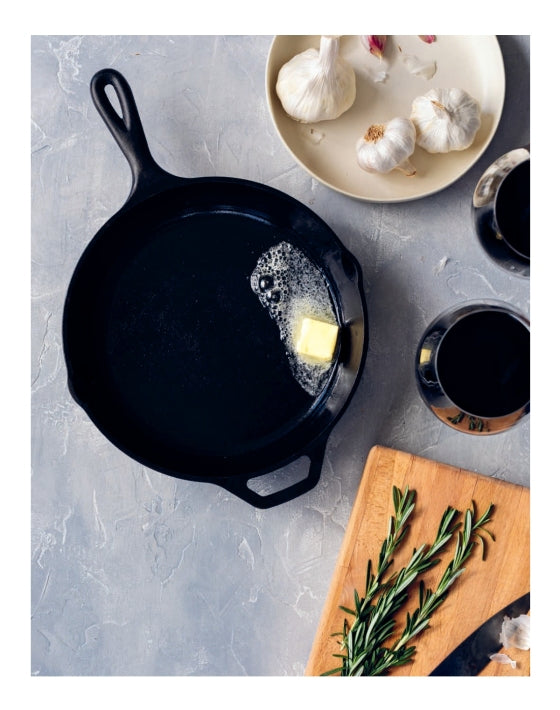 The Couple’s Cookbook from Penguin Random House sets the scene for shared culinary adventures: A cast iron skillet melts a pat of butter, while nearby a wooden board with rosemary, a plate of garlic bulbs, and two cups of dark liquid invite couples to cook and savor delicious moments together.