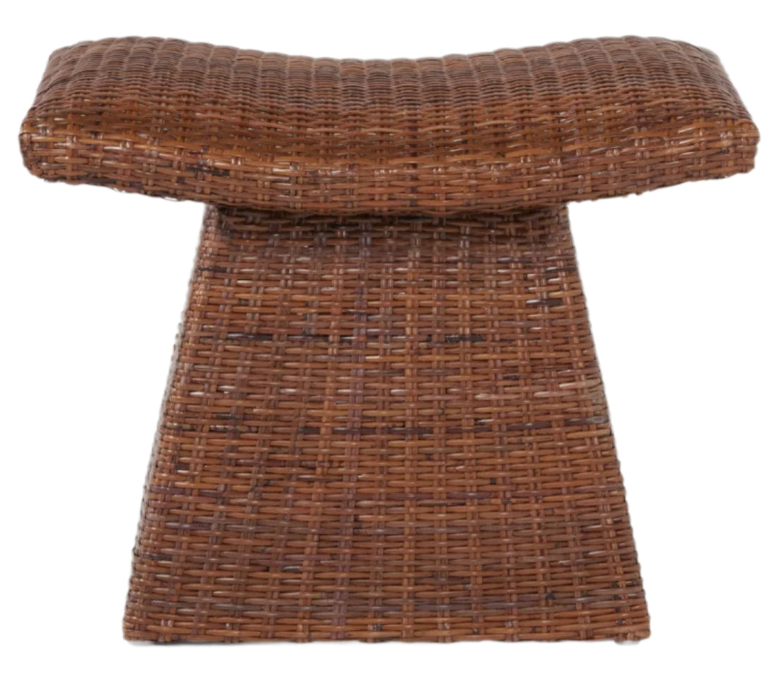 The Connie Foot Stool by Made Goods features a lightweight woven rattan design with a saddle-shaped seat and flared rectangular base—an elegant accent for any space. Shown against a white background.