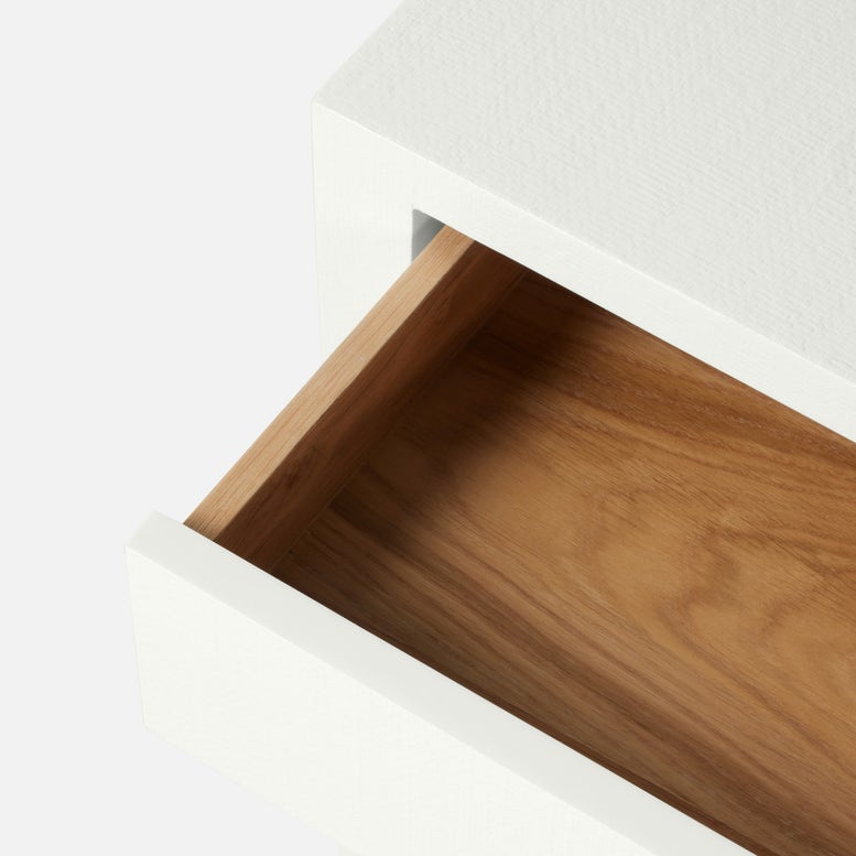 A close-up of an open white drawer with a wooden interior, part of the Conrad Desk by Made Goods, set against a plain background.