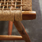 Close-up of the Corenne Bench by Made Goods, featuring a loomed fiber seat and Scandinavian design, displayed on a gray textured floor.
