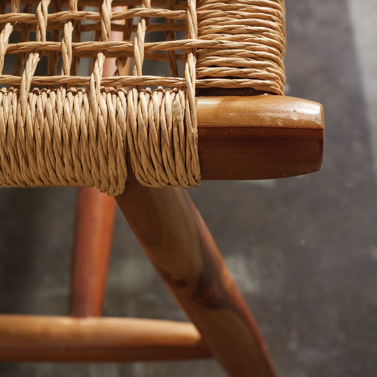 Close-up of the Corenne Bench by Made Goods, featuring a loomed fiber seat and Scandinavian design, displayed on a gray textured floor.