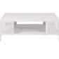 The Isla Coffee Table by Made Goods features a rectangular white rattan design with an open lower shelf, displayed against a plain white background.