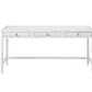 The Isla Desk by Made Goods is a rectangular white desk with three front drawers, each with a small round gold knob, and simple straight legs.