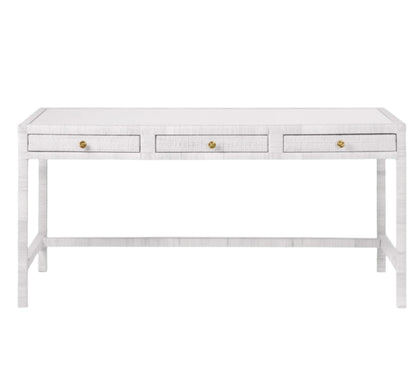 The Isla Desk by Made Goods is a rectangular white desk with three front drawers, each with a small round gold knob, and simple straight legs.