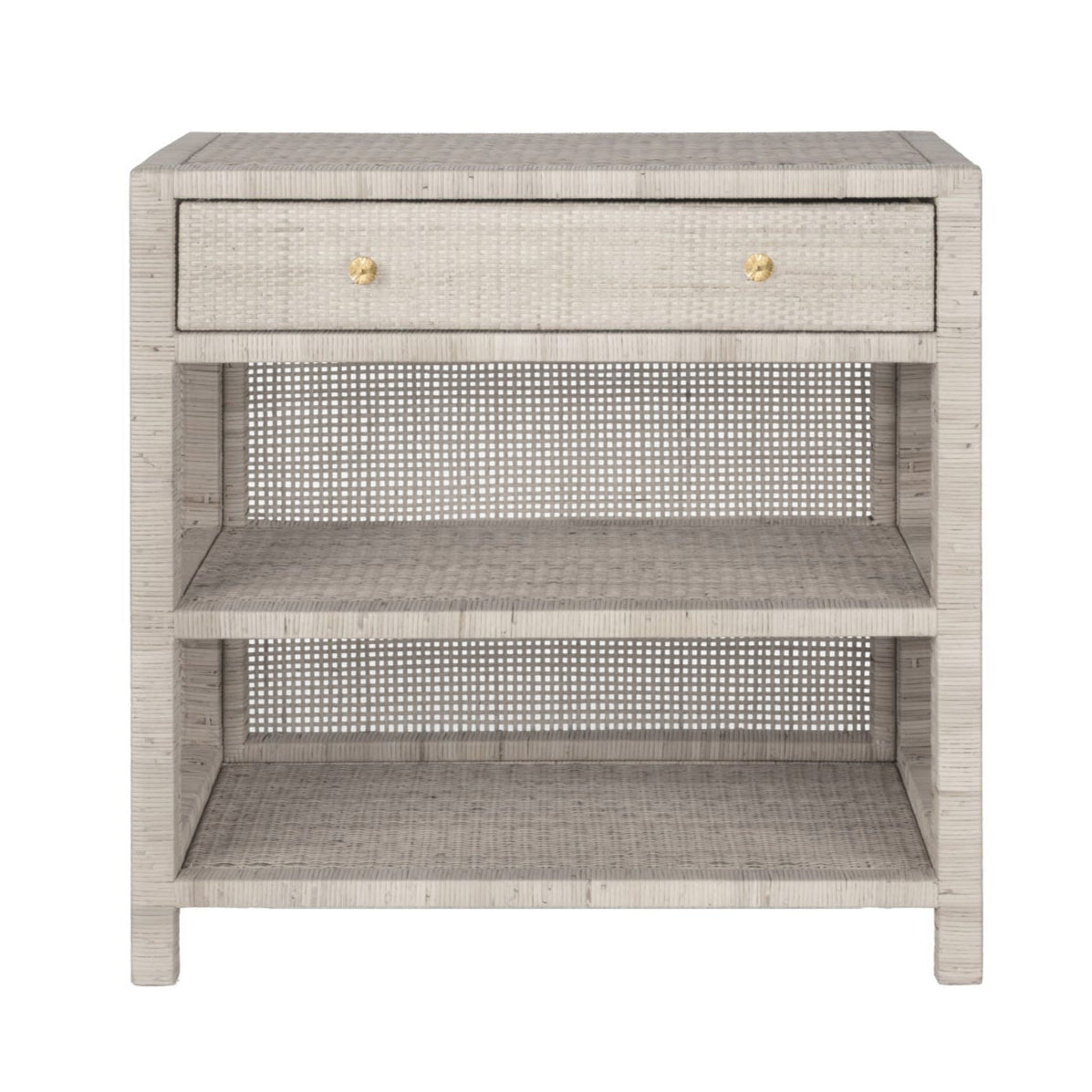 The Made Goods Isla Nightstand Collection features a light gray wicker nightstand with basket weave design, one drawer with two round knobs, and two open lower shelves.