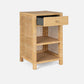 The Isla Nightstand Collection by Made Goods features a rectangular basket weave rattan frame, one soft-close top drawer (partially open), an open shelf, and a lower shelf.