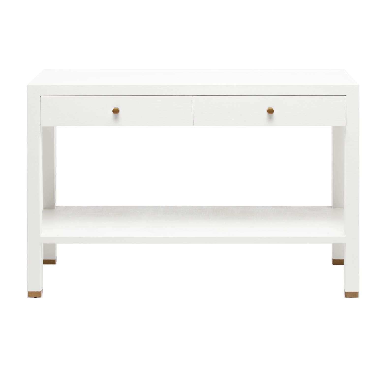 The Jarin Console Collection by Made Goods features a white wooden desk with a simple silhouette, two drawers with brass-hued knobs, textured finish, open lower shelf, and brass-accented feet, shown against a white background.