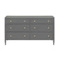The Jarin Dresser Collection by Made Goods is a gray linen dresser with six drawers, gold round knobs, and tapered legs, shown from the front against a plain background.