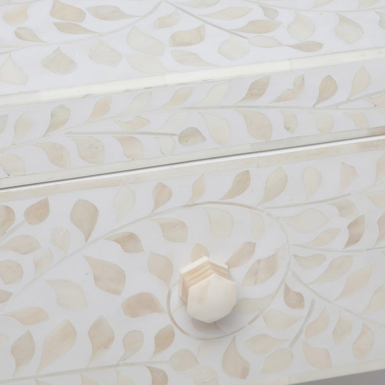 Close-up of a drawer from the Made Goods Lexi Nightstand, featuring a geometric knob and an Indian-inspired white and beige leaf inlaid pattern crafted from camel bone.