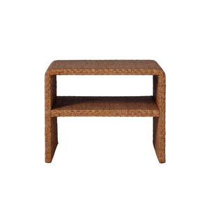 The Lynette Side Table in Dark Rattan by Made Goods features a rectangular silhouette with a Lynette-inspired woven facade, rounded edges, and an open lower shelf, shown against a plain white background.