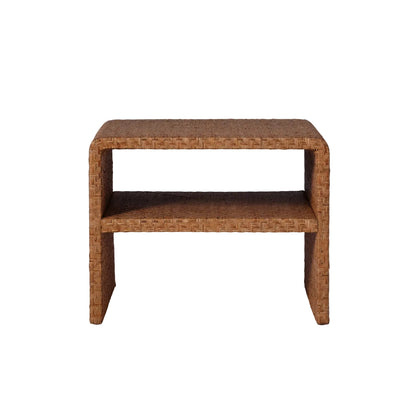 The Lynette Side Table in Dark Rattan by Made Goods features a rectangular silhouette with a Lynette-inspired woven facade, rounded edges, and an open lower shelf, shown against a plain white background.