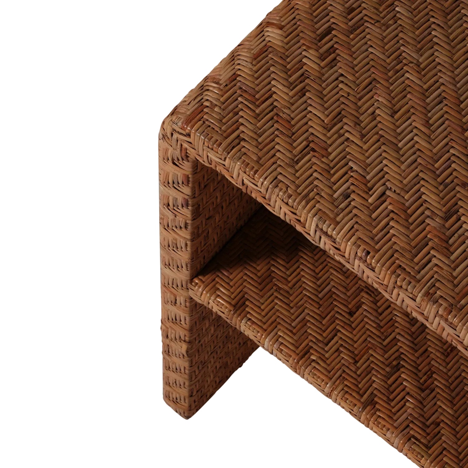 Close-up of the Lynette Side Table in Dark Rattan by Made Goods, featuring a rectangular woven rattan design with a lower shelf, showcasing the herringbone pattern and corner detail against a white background to highlight its elegant facade.