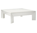 The Roberts Coffee Table by Made Goods is a modern square white table with a flat top and thick, uniquely shaped legs, showcased against a plain white background.