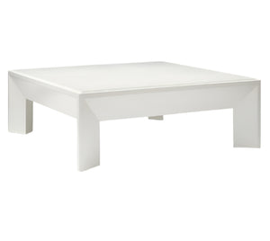 The Roberts Coffee Table by Made Goods is a modern square white table with a flat top and thick, uniquely shaped legs, showcased against a plain white background.