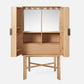 The Vanna Bar Cabinet by Made Goods features open doors that reveal shelves, a drawer, a mirrored back, and hanging hooks, all supported by a matching wood stand with crossbar legs in an elegant oak veneer.