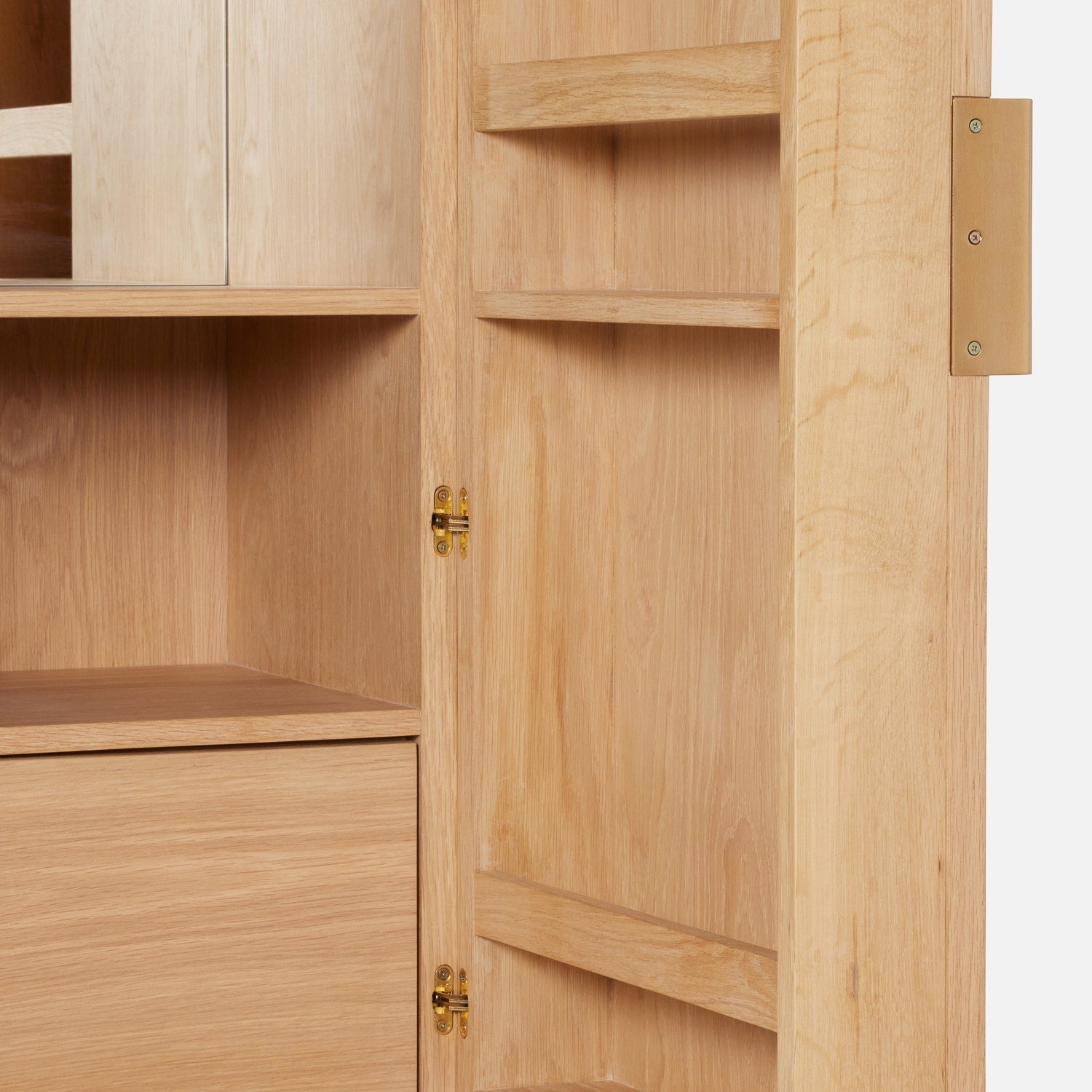The Vanna Bar Cabinet by Made Goods features an oak veneer door with a brass plate, brass hinges, and interior shelves revealed when its wooden bar cabinet door is opened.