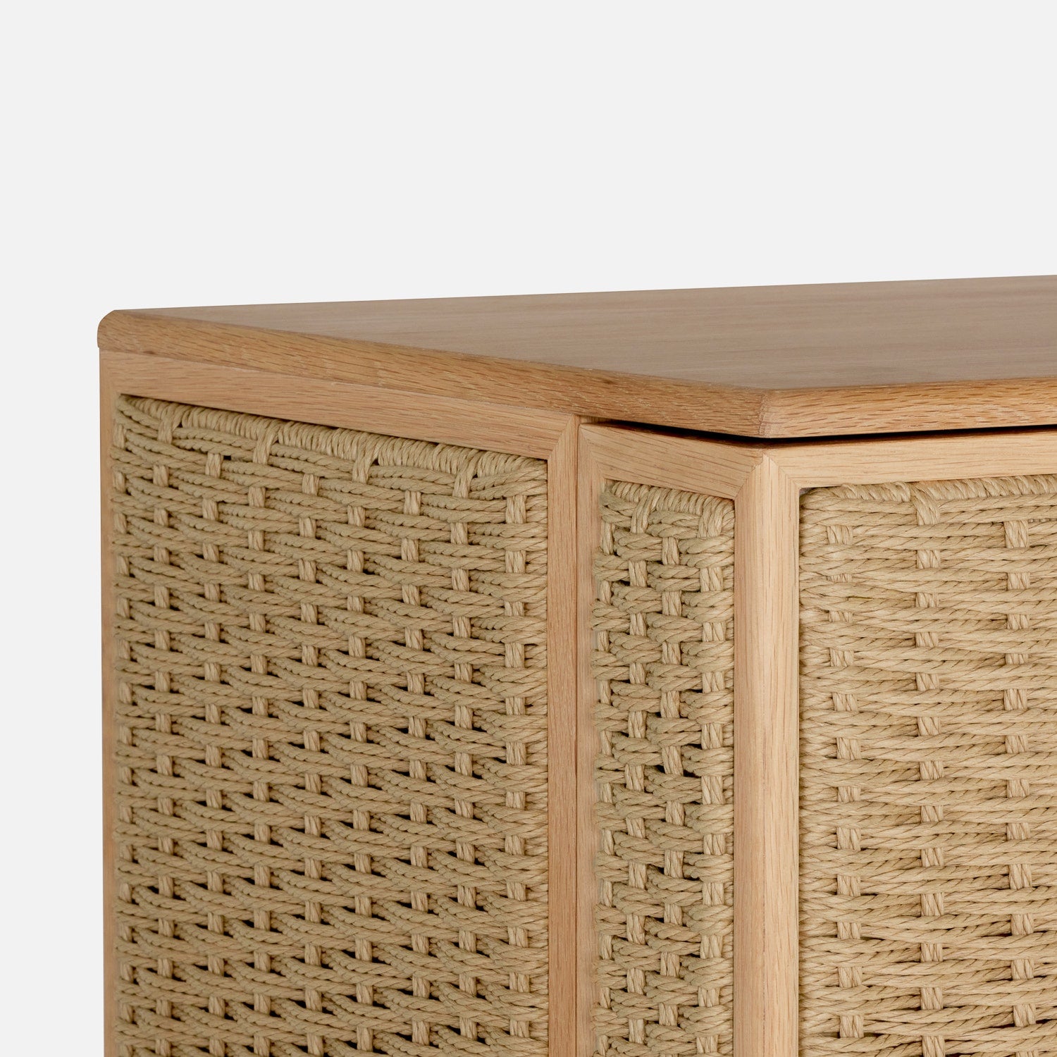 Close-up of the Vanna Bar Cabinet by Made Goods, featuring oak veneer and woven rattan panels on its sides and front, set against a plain white background.