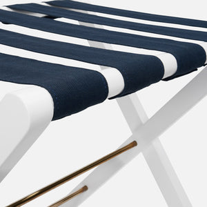 Close-up of the Made Goods Walvia Luggage Rack, featuring a white duco frame and navy canvas straps across the seat.