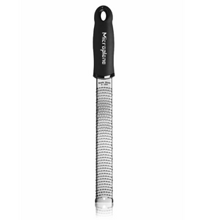 The Microplane Premium Classic Zester in black, manufactured by Microplane, features a narrow, surgical-grade stainless steel grating surface that ensures precision and durability. Its ergonomic handle provides a comfortable grip for effortless zesting.
