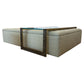 The HIVE Tufted Ottoman with Table in Landscape Kaki features a beige tufted design and an attached glass and metal accent frame, adding a modern touch to any room. This custom piece combines style and functionality.