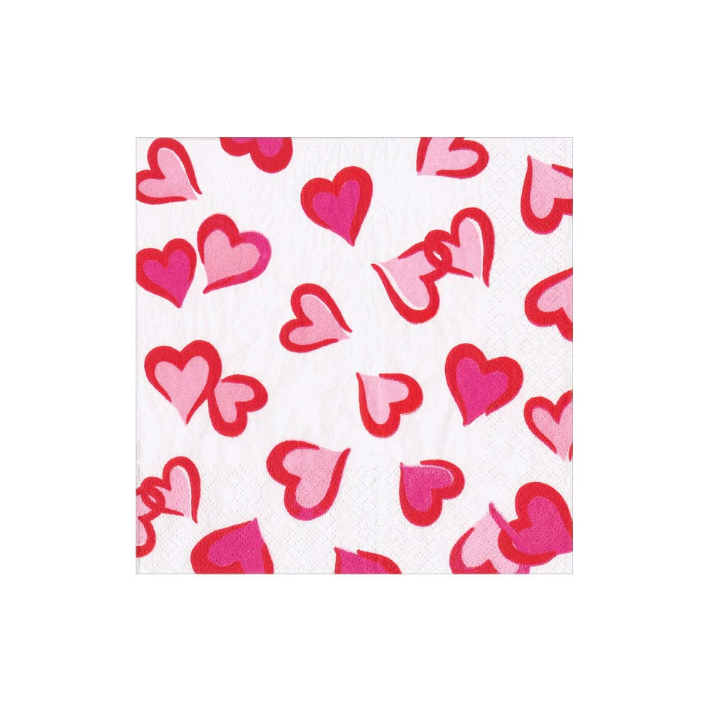 Heartfelt Cocktail Napkins by Caspari feature a white triple-ply design with pink and red hearts. These biodegradable napkins add eco-friendly charm and style to any setting.