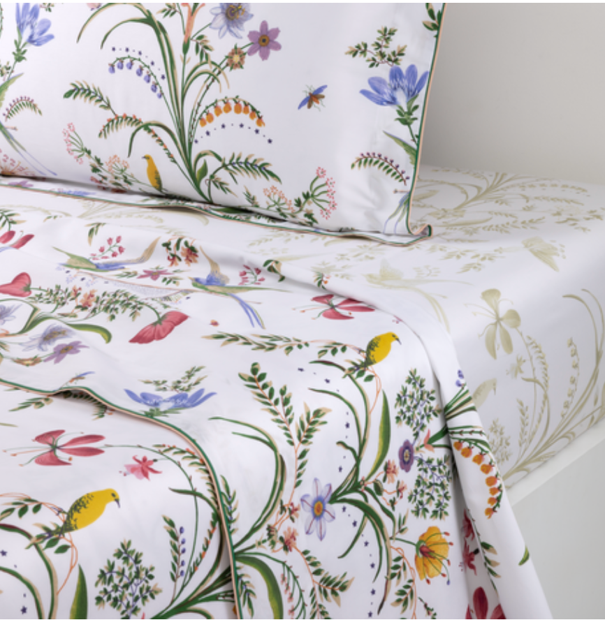 Yves Delorme Botanic Bedding Collection white organic cotton sateen linens featuring a colorful botanical print of meadow flowers, birds, and insects.