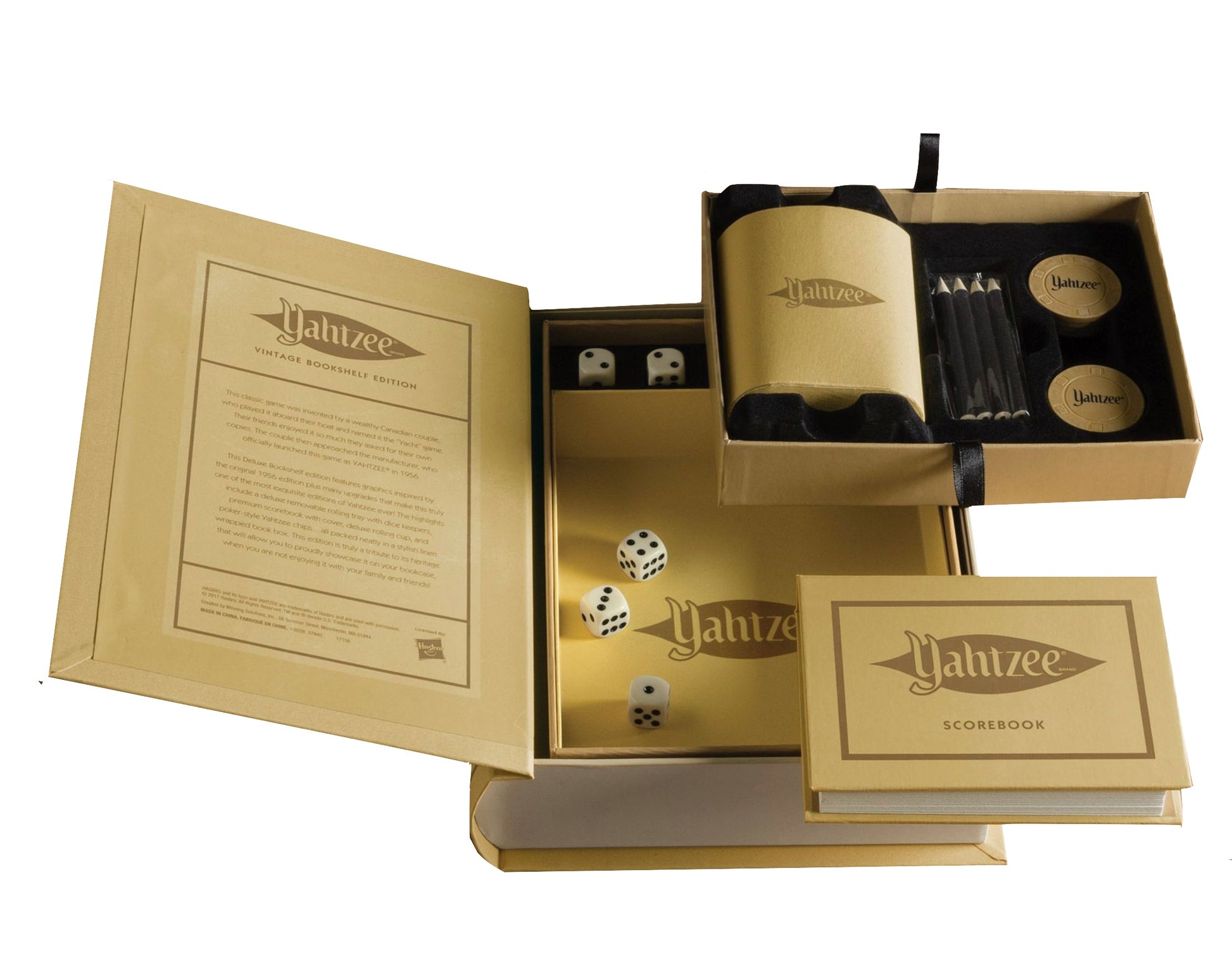 The WS Game Company's Yahtzee Vintage Bookshelf Edition game set includes a deluxe rolling tray, dice, scorebook, scorecards, and containers. All components are elegantly housed in a gold-colored box designed to resemble a book. Enjoy the charm of vintage-inspired graphics as you immerse yourself in this classic game.