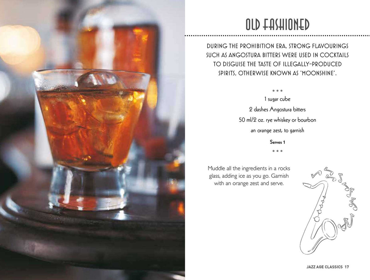 Two glasses of Old Fashioned cocktails with ice and orange garnish sit on a tray next to “Gatsby Cocktails” by Simon & Schuster, which features the drink’s recipe and history, celebrating its legacy among classic cocktail recipes and iconic 1920s cocktails.