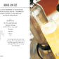 Two tall glasses of royal gin fizz are being filled with a fizzy liquid from a siphon, their tops crowned with foam in a close-up shot. On the left, Gatsby Cocktails by Simon & Schuster features the recipe for this classic Prohibition-era drink, capturing the timeless appeal of 1920s cocktails.
