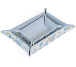 The Luxe Saffiano Tray Set Collection by TRVL Design features a rectangular, blue and white floral-patterned valet tray with a striped interior, saffiano finish, and gold snap buttons—ideal for pocket-sized organization.