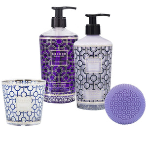The Baobab Gentlemen Body Wellness Collection features a candle, body wash, hand lotion, and round soap in vibrant purple and blue packaging, evoking the allure of an oriental perfume for a luxurious experience.