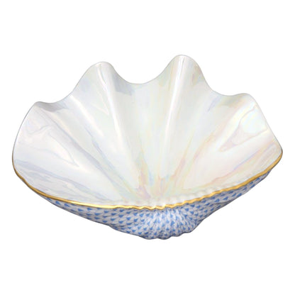 The Reserve Collection Giant Clam by Herend is a white porcelain bowl shaped like a clam shell, with a glossy finish, blue textured base, and gold trim—evoking the elegance of Chinese ceramics admired by Marco Polo.