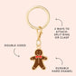 The Foggy Dog Gingerbread Man Collar Charm is a gold keyring with a double-sided gingerbread man and red bow tie, sturdy hard enamel, and two attachment options—ideal as a festive accessory or playful pet collar charm.