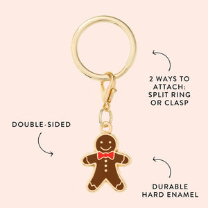The Foggy Dog Gingerbread Man Collar Charm is a gold keyring with a double-sided gingerbread man and red bow tie, sturdy hard enamel, and two attachment options—ideal as a festive accessory or playful pet collar charm.
