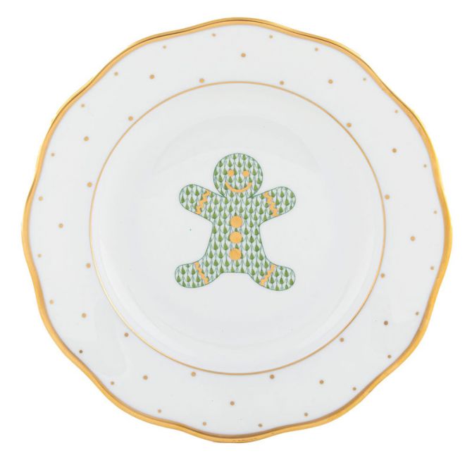This Herend Christmas Gingerbread Man Dessert Plate features a gold-rimmed gingerbread man design, accented with green trees and yellow buttons.