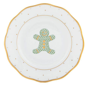 This Herend Christmas Gingerbread Man Dessert Plate features a gold-rimmed gingerbread man design, accented with green trees and yellow buttons.